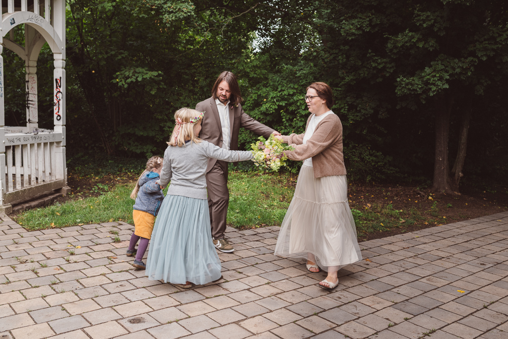 Brautpaar tanzt mit seinen Kindern Ringelreihe im Johannapark beim Portraitshooting