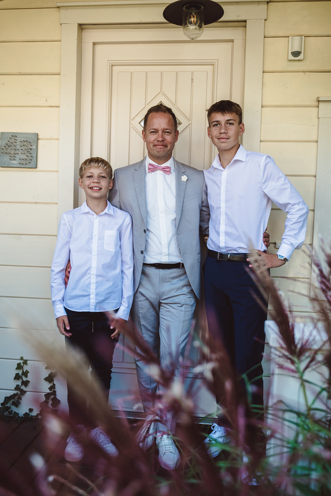 Bräutigam mit seinen beiden Söhnen vor einer Ferienwohnung