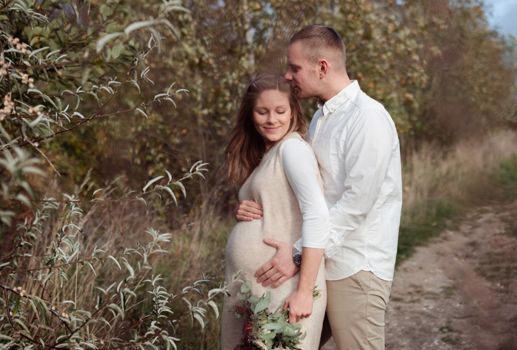 Foto vom Fotoshooting eines schwangeren Paares in der Natur, um Fotos ihrer Schwangerschaft festzuhalten