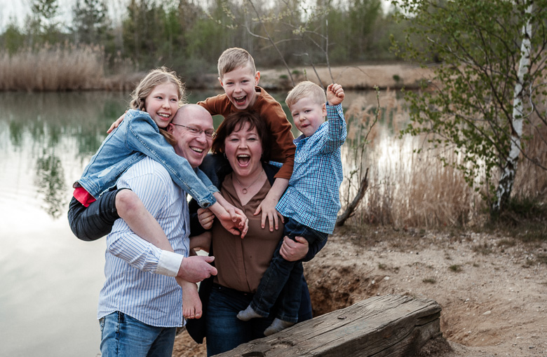 Fröhliche fünfköpfige Familie steht an einem See beim Familien Fotoshooting in Leipzig