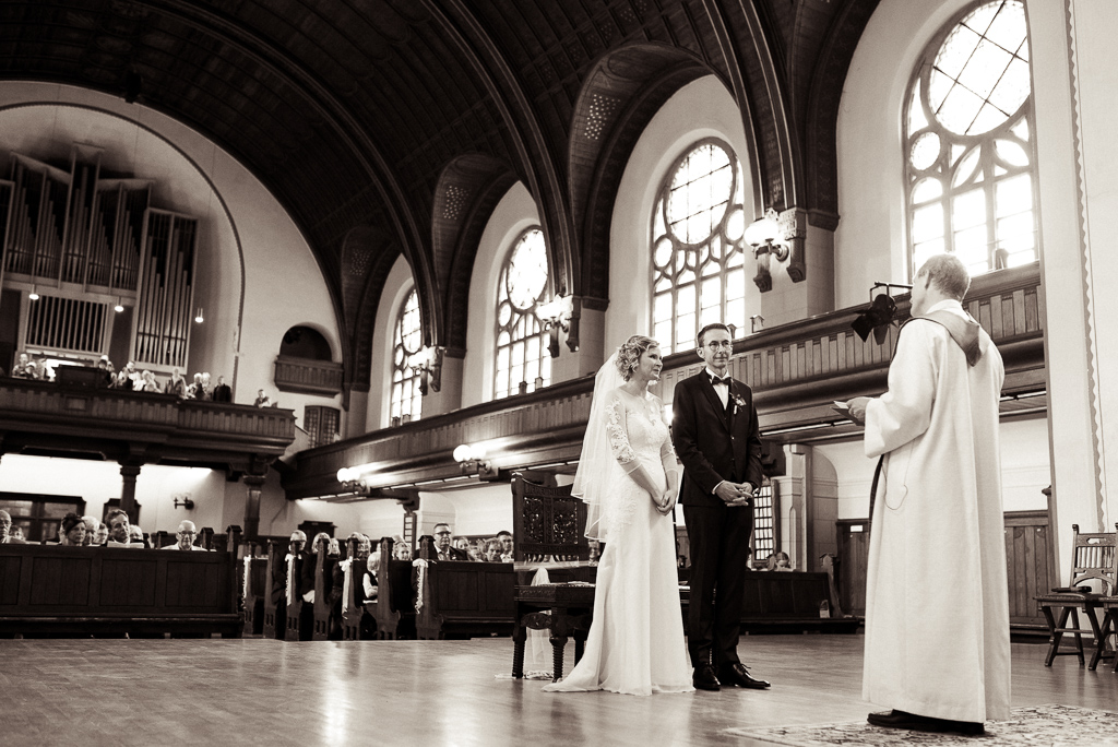 Hochzeitsfotos mit Brautpaar und Pfarrer in der Kirche