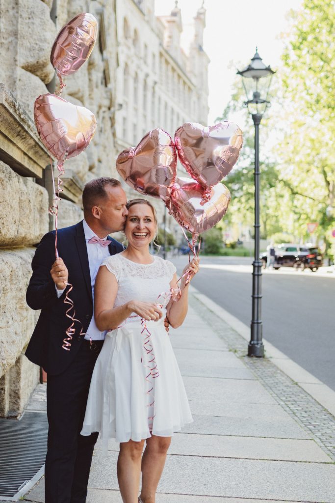 Brautpaar vor dem Standesamt leipzig bei ihrem Brautpaar Shooting mit Herz Luftballons in der Hand